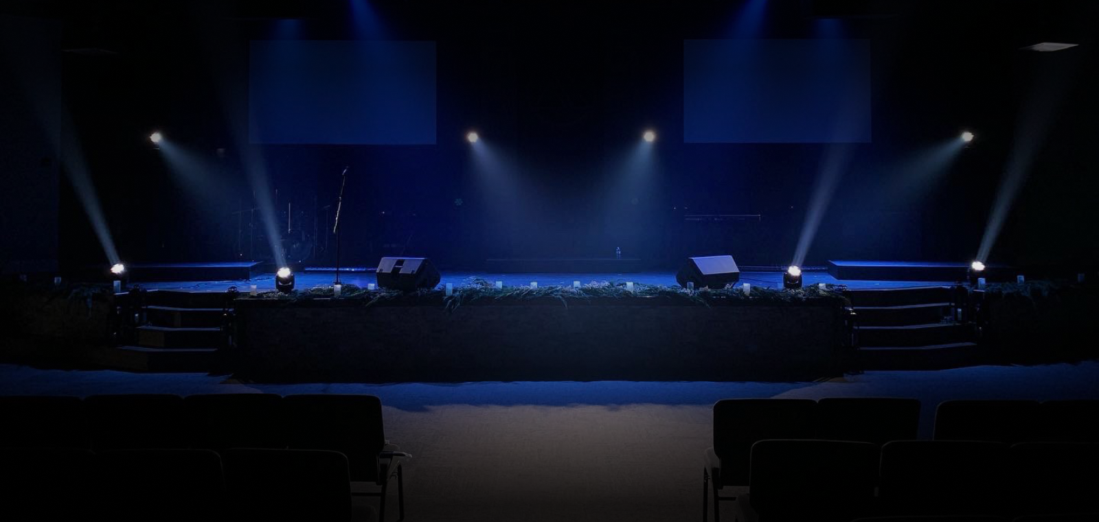Blue dimmed stage with beams of white light