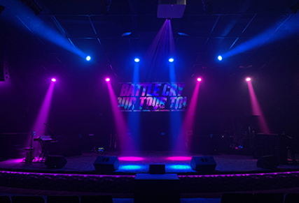 Stage with blue and magenta beams with text on the screen
