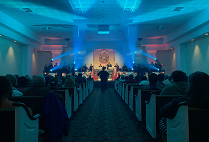 Light blue church event with Christmas wreath center stage
