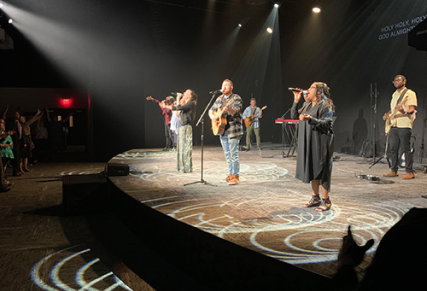 band on stage playing instruments and singing