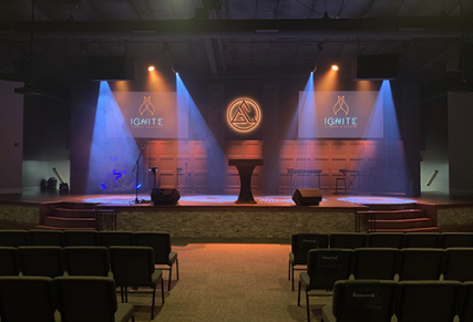 Stage altar with predominantly orange lighting with blue beams