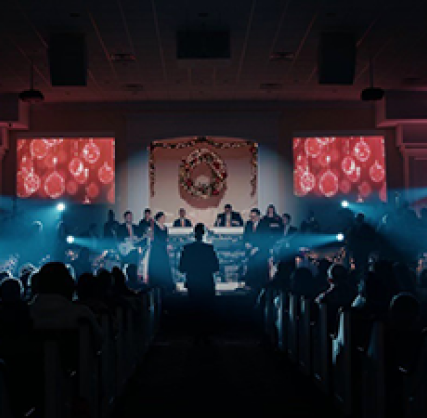 Church altar with white light beams and wreath center stage