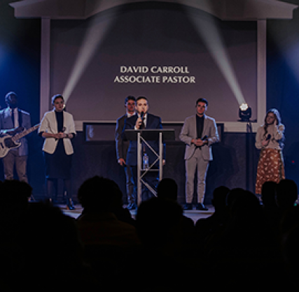 Pastor on stage with two light beams in background