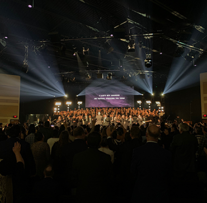 Stage with choir and musicians performing with white light beams