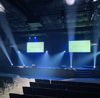 Blue lit stage with teal-green screens