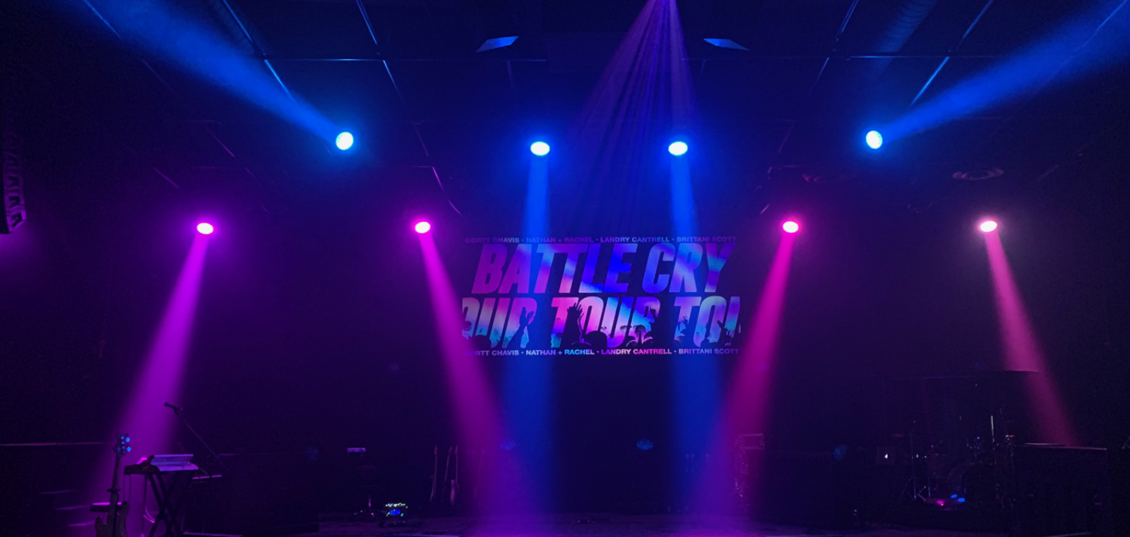 Stage with blue and magenta beams with text on the screen
